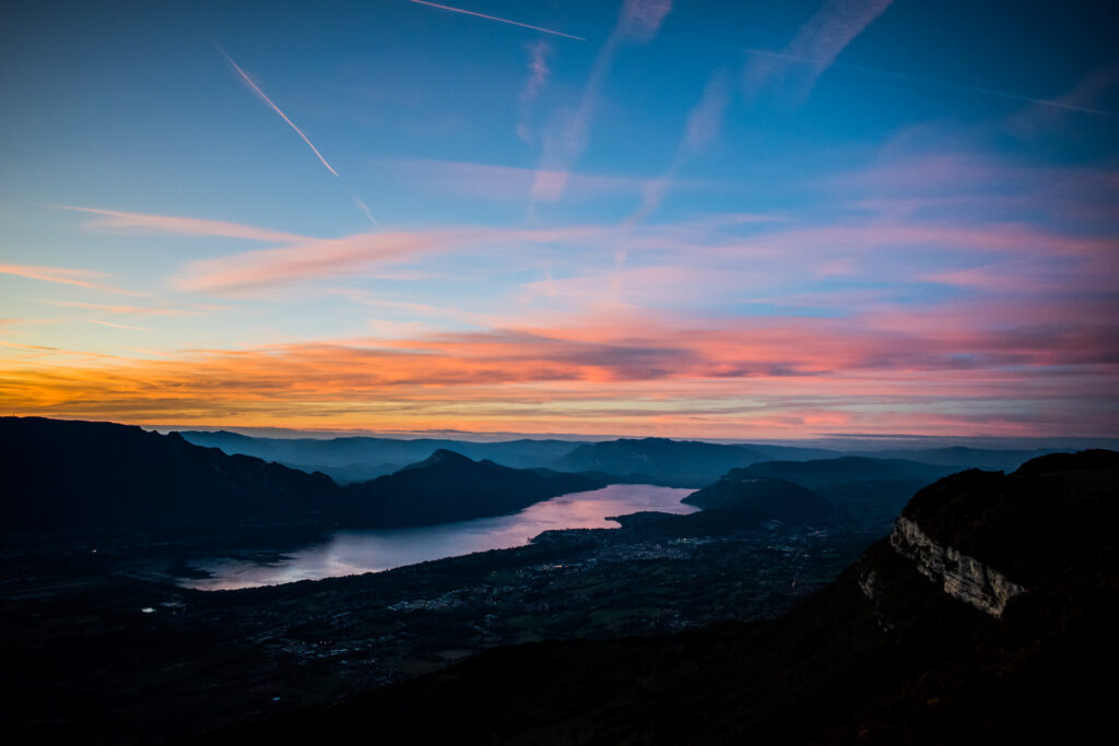 Tranquil mountain sunset with winding river reflecting vibrant orange pink and blue sky colors Wallpaper