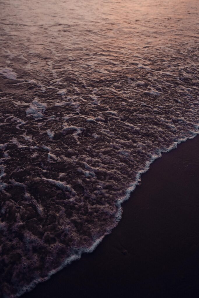 Tranquil beach wallpaper with gentle ocean waves and warm dusk lighting on sandy shore