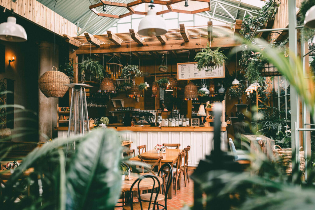 Plant-Filled Oasis: A Serene Outdoor Cafe Scene Wallpaper