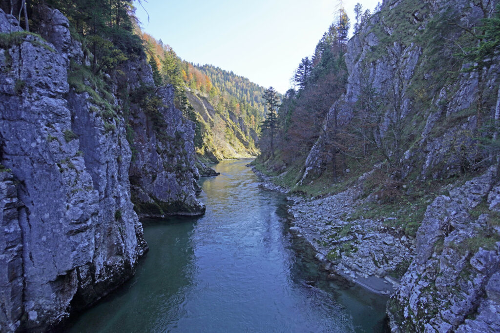 High-resolution wallpaper of a tranquil river winding through rocky cliffs and lush green forest