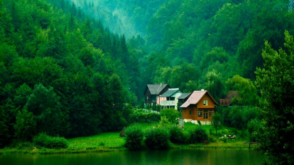 Serene Waterside Retreat: Blissful Cottages Amidst Lush Greenery Wallpaper