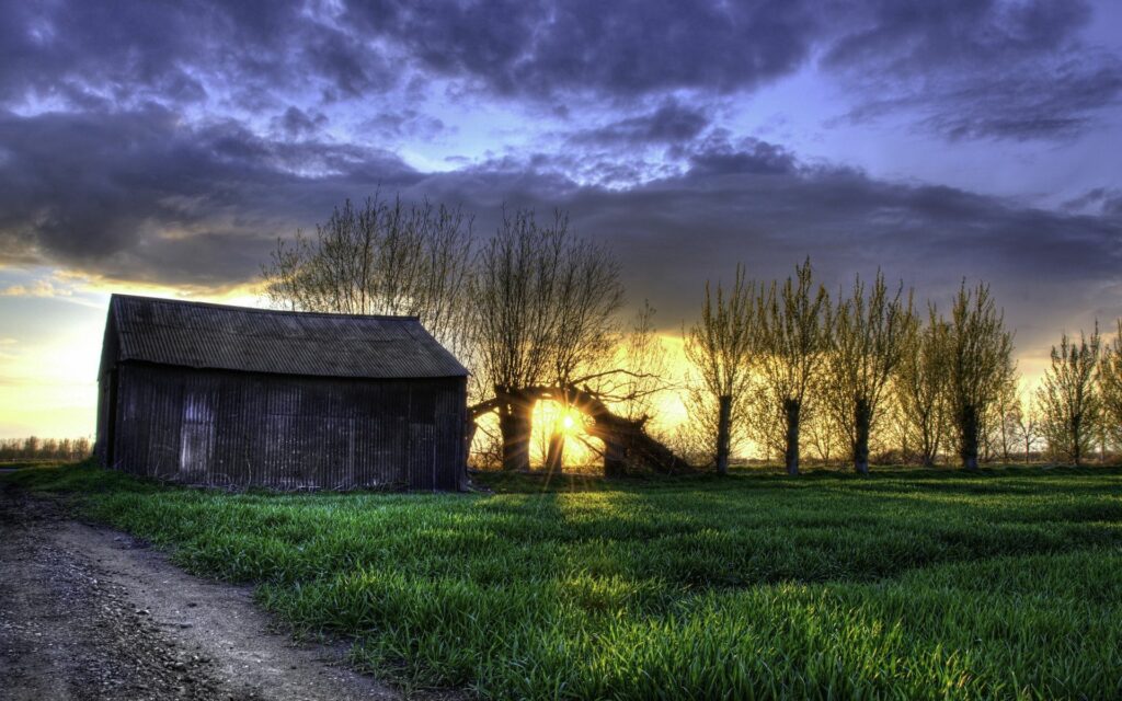 Tranquil rural night scene with rustic barn grassy field vibrant sky sunset HDR wallpaper background