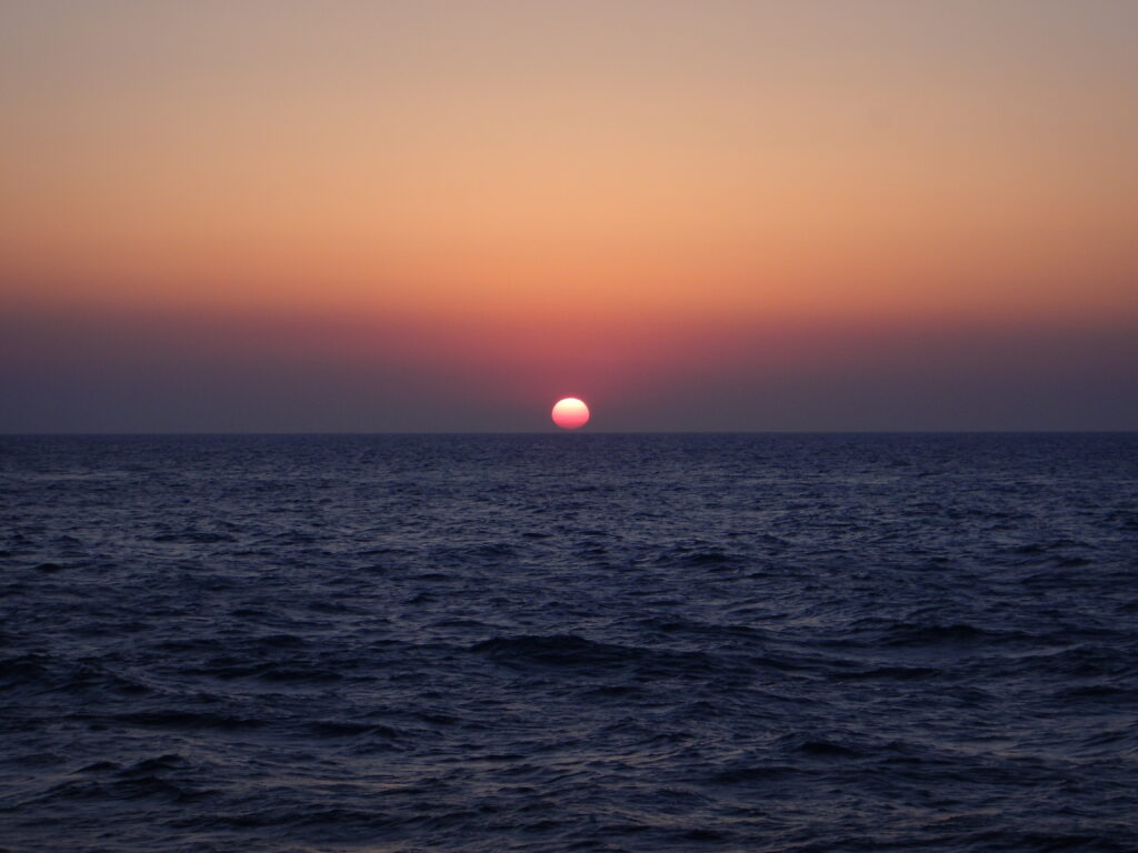 Tranquil sea waves under vibrant sunset sky creating peaceful nature wallpaper background