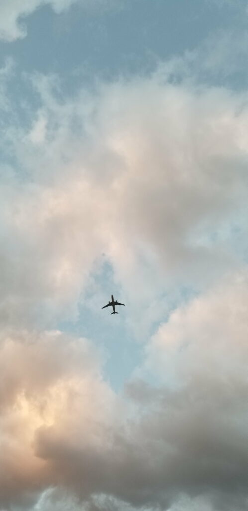 Serene Sky HD Wallpaper: Fluffy Clouds & Plane in Tranquil Background