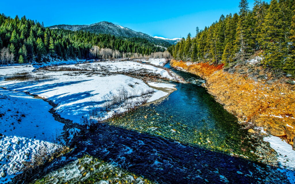 Nature's Serenity Revealed: Majestic Trinity Alps Shimmer on Spring River Wallpaper