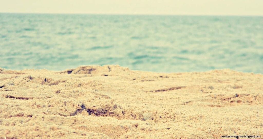 Tranquil Beach Sunset: Soft Sands & Gentle Sea in Golden Glow Wallpaper