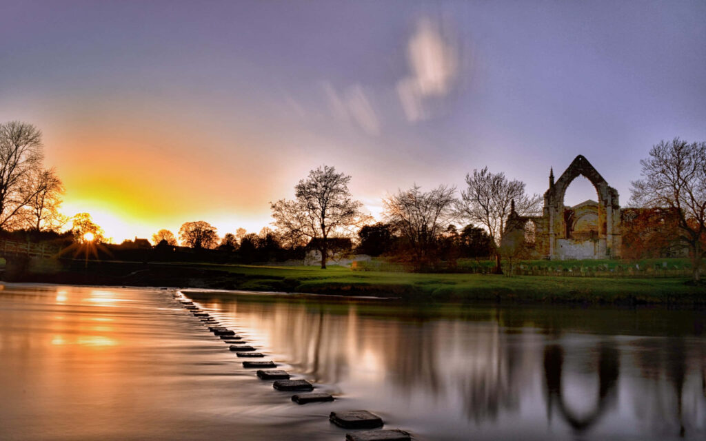Tranquil Sunset Landscape with Ancient Ruins and Calm River Reflections Wallpaper