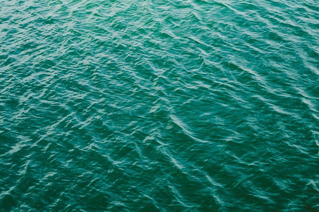 Calm teal sea wallpaper with gentle ripples and soft natural light for serene aquatic background