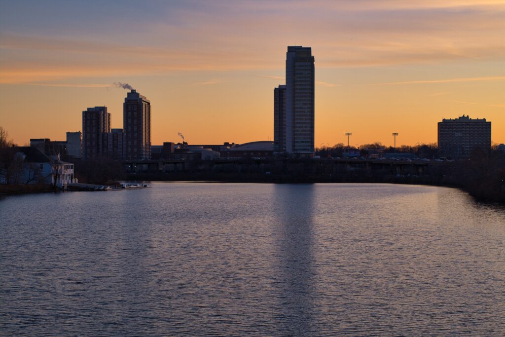Twilight Cityscape Wallpaper: Serene Sunset Reflection on Lake