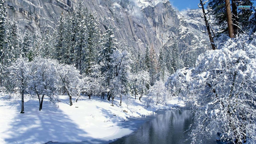 Winter landscape with snow-covered forest river and towering granite cliffs bright nature wallpaper