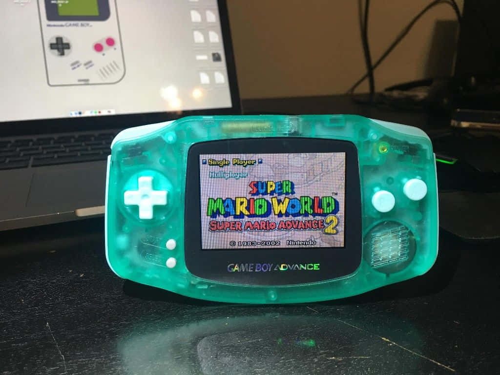 Close-up translucent teal Game Boy Advance showing Super Mario Advance 2 title screen retro gaming Wallpaper