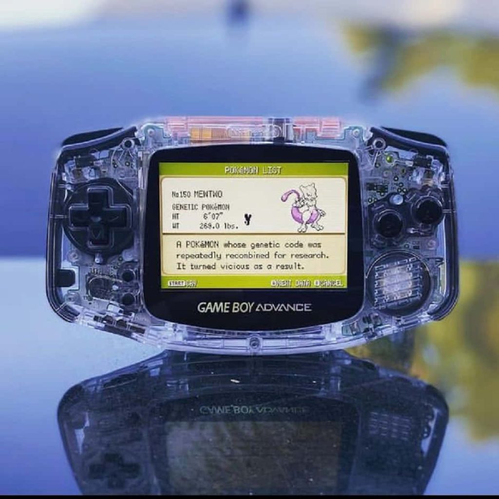 Transparent Game Boy Advance showing Mewtwo Pokédex entry on reflective surface wallpaper background