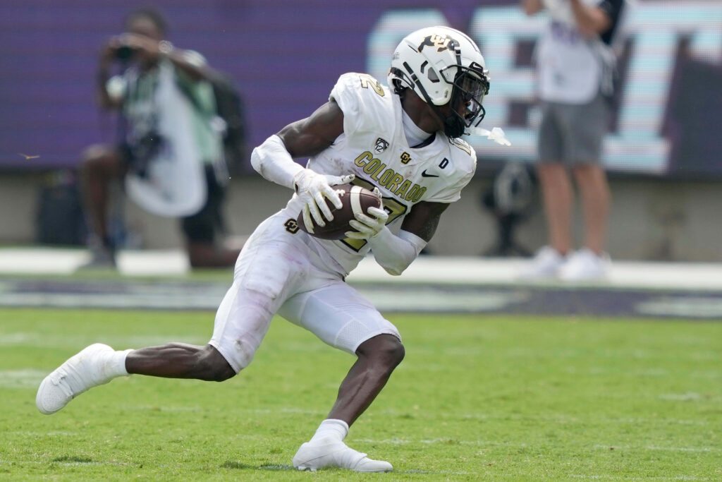 Travis Hunter Colorado Buffaloes football player in white and gold uniform in action on field Wallpaper