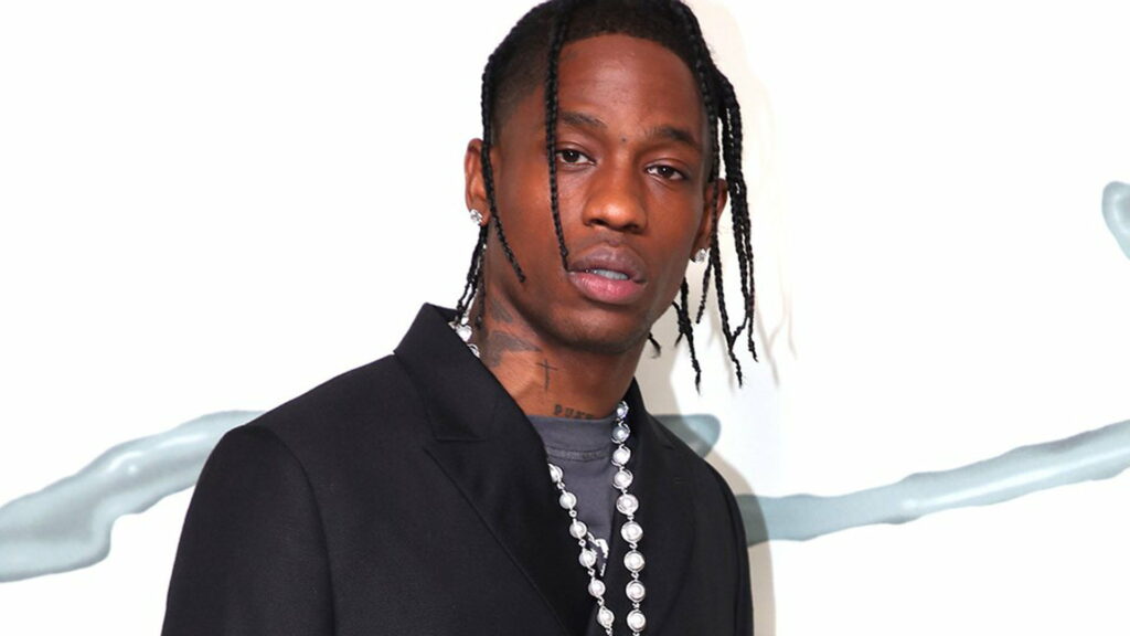 The Iconic Style of Travis Scott: Exuding Confidence in a Sleek Black Overcoat and Silver Chain Wallpaper