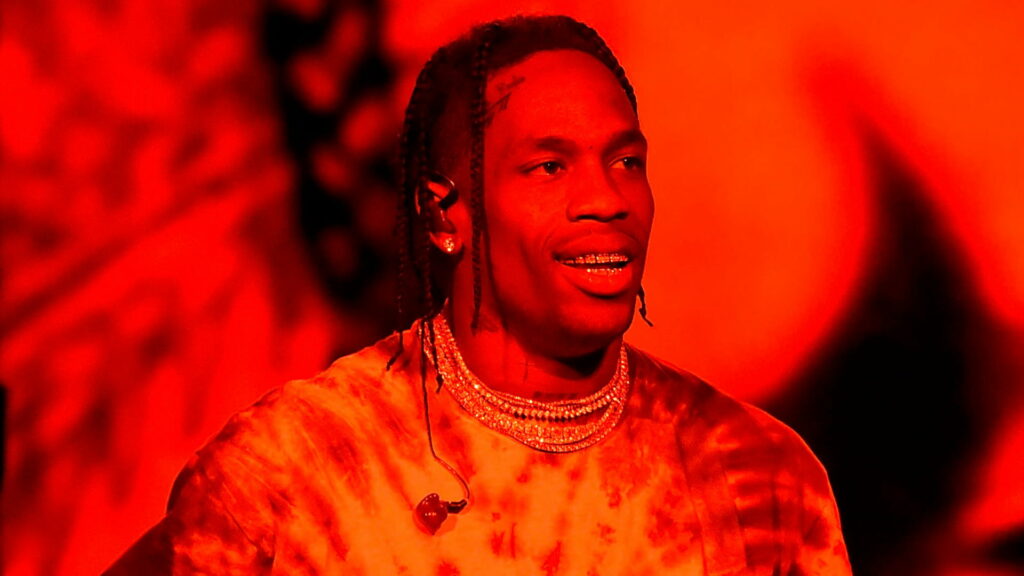 Travis Scott Flaunting Bold Style on Vibrant Red Background: A Glamorous HD Wallpaper