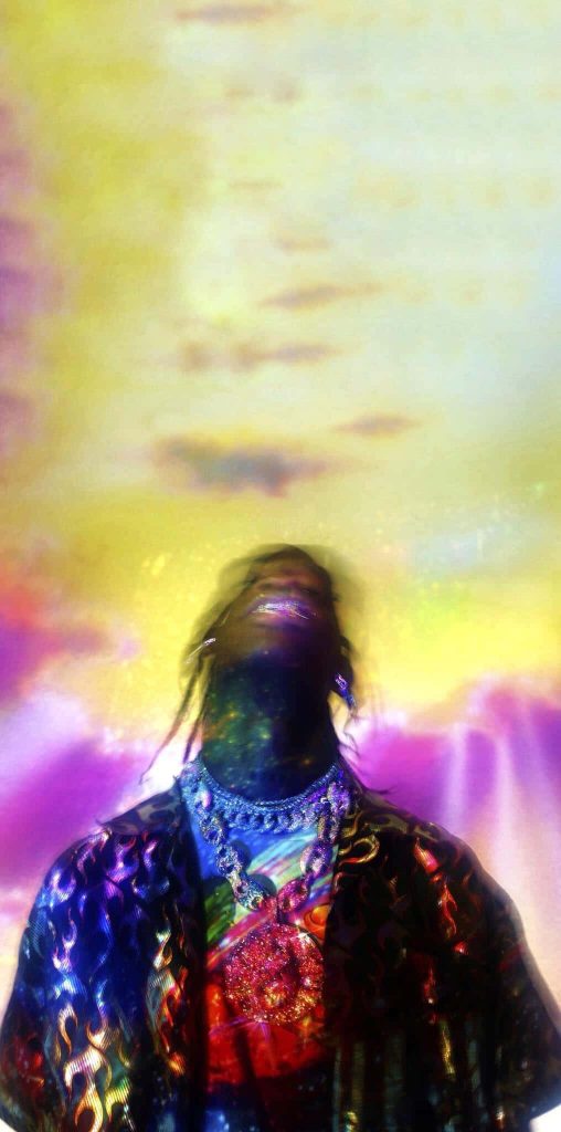 Psychedelic Travis Scott portrait wallpaper with cosmic yellow purple lighting chains and grillz
