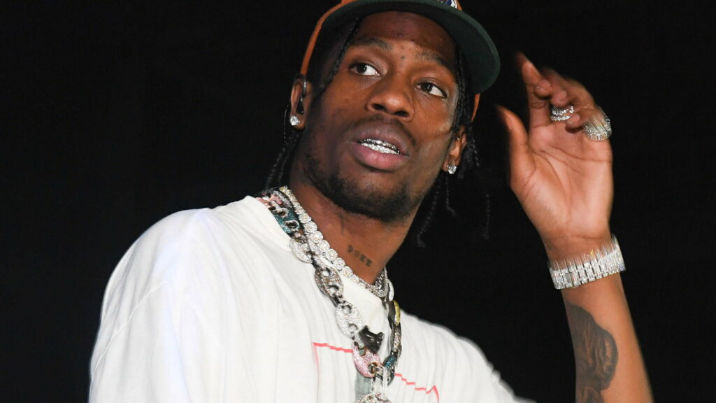 Travis Scott's Edgy Style: Rocking a Fresh White Tee and Bold Chains as a Fashion Statement Wallpaper