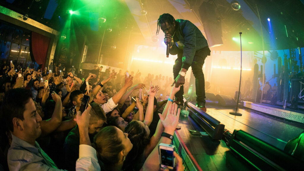 Travis Scott Takes the Stage: Captivating HD Wallpaper of the Rapper Entertaining Fans with Interactive Performance