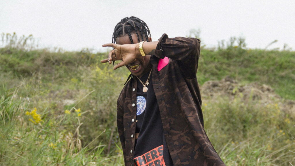 Travis Scott: Mysterious Swagger in Black and Brown Attire with Gold Chain Accents - QHD Wallpaper