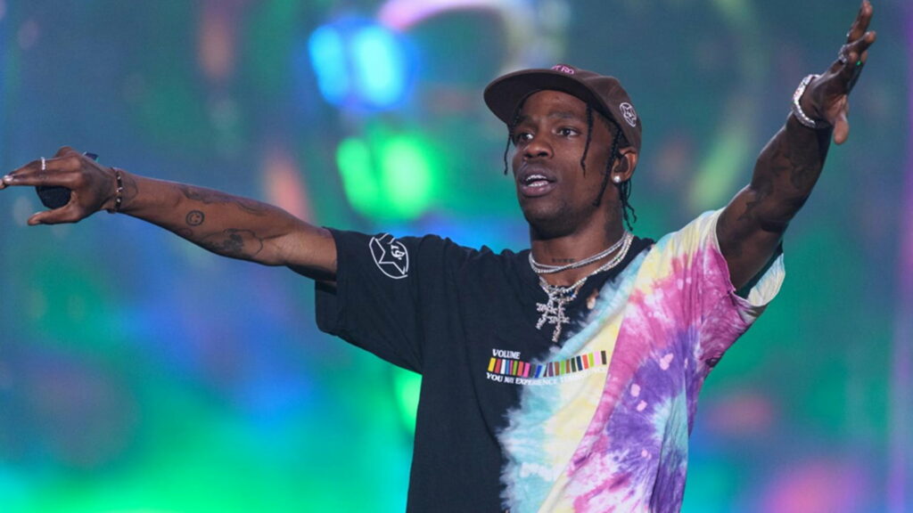 Travis Scott Standing Strong amidst Vibrant Lights: A Captivating HD Wallpaper