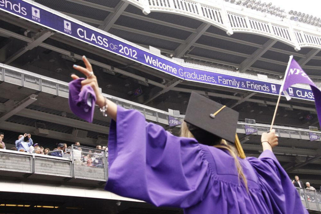 Triumphant NYU Graduate Celebrating in Graduation Attire amid 2022 Ceremony Wallpaper