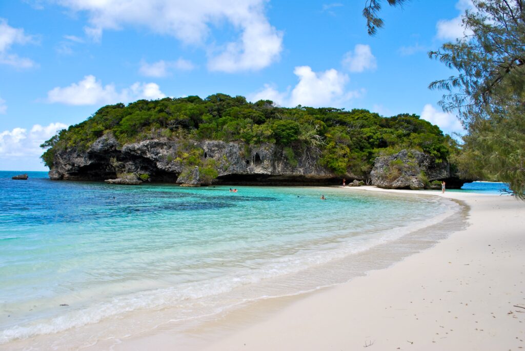 Tropical beach wallpaper with turquoise water white sand green island bright blue sky clouds