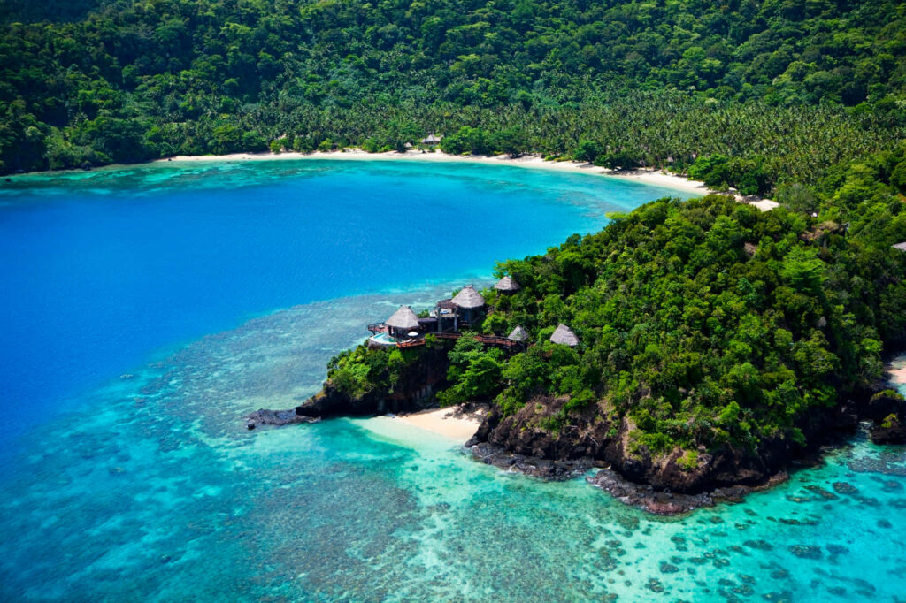 Tranquil Tropical Coastline: Aerial View of Lush Greens & Turquoise Waters Wallpaper