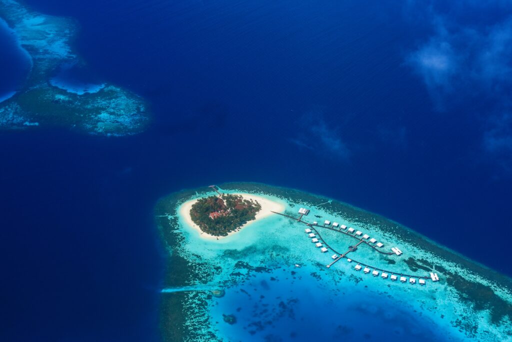 Aerial view of a tropical island with turquoise waters coral reefs and vibrant ocean blues wallpaper