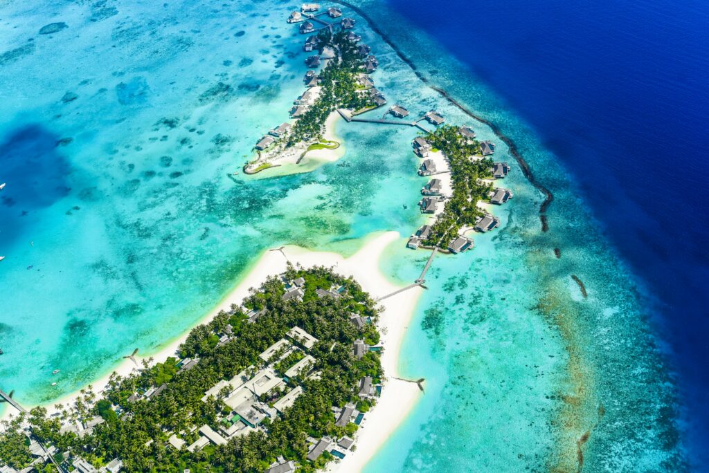 Aerial view of tropical island paradise with turquoise ocean lush greenery and luxury villas wallpaper