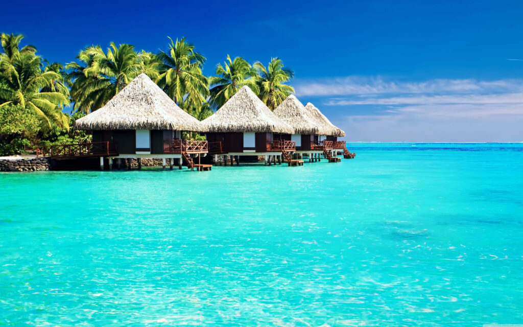 Tranquil Tropical Paradise Wallpaper: Huts, Palm Trees & Blue Waters