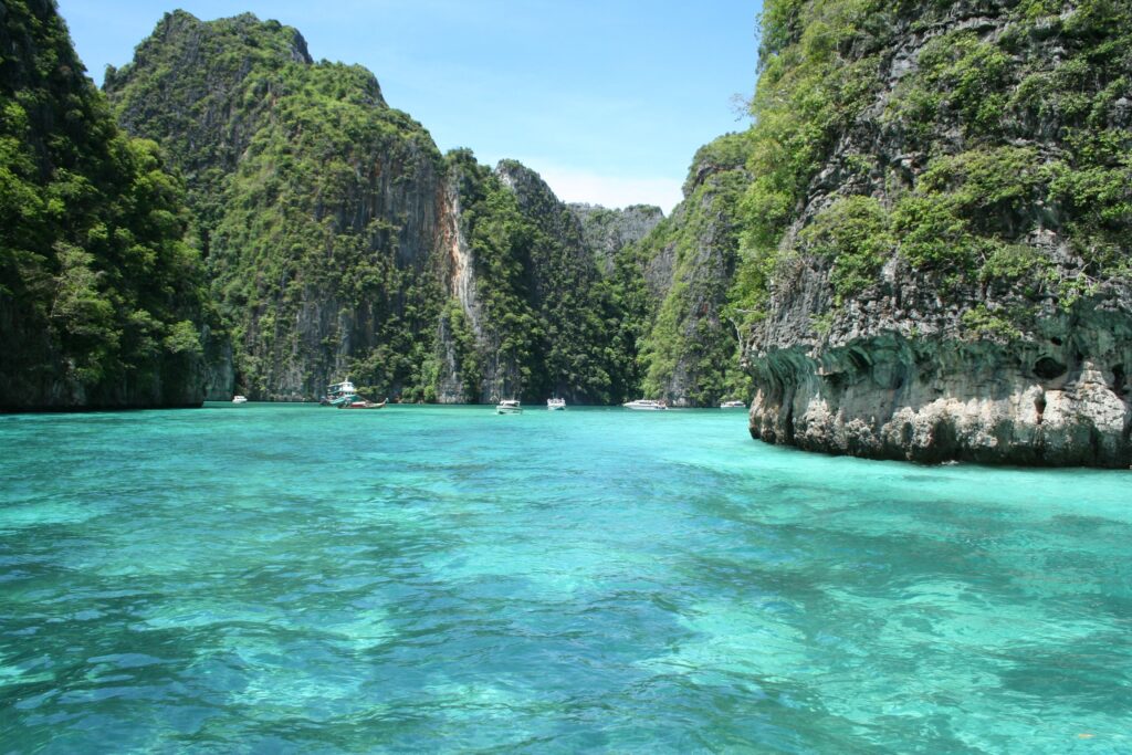 Tropical paradise wallpaper with turquoise sea limestone cliffs lush greenery and bright blue sky