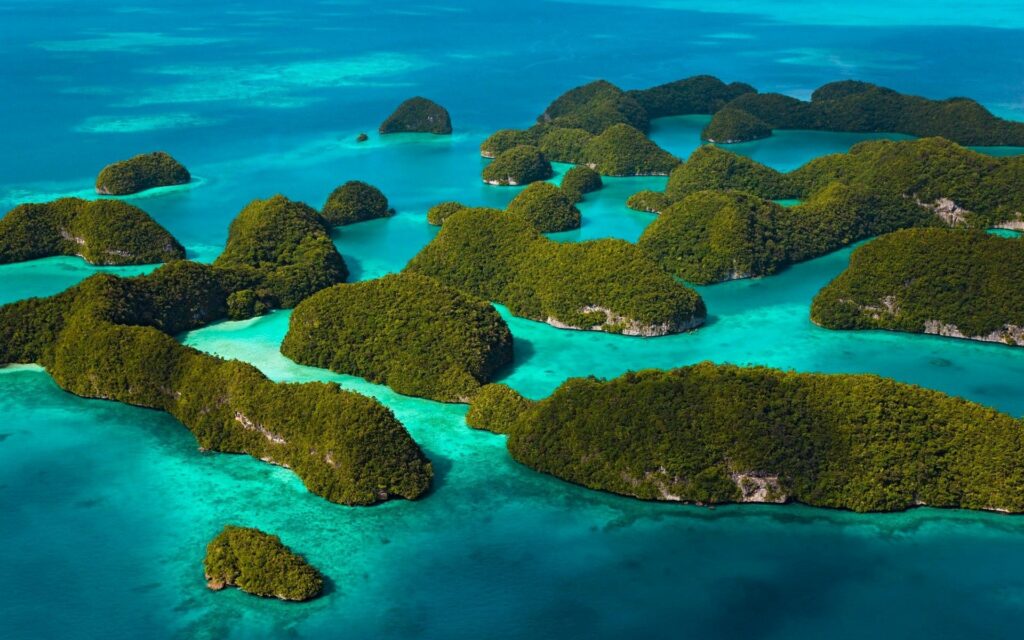 Aerial view of lush green islands and turquoise waters in a vibrant tropical paradise wallpaper