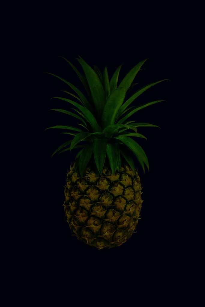 Tropical Pineapple Wallpaper: Lush Green Leaves on Dark Background