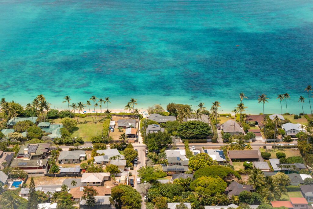 Aerial view of tropical seaside houses surrounded by palm trees and clear turquoise water wallpaper