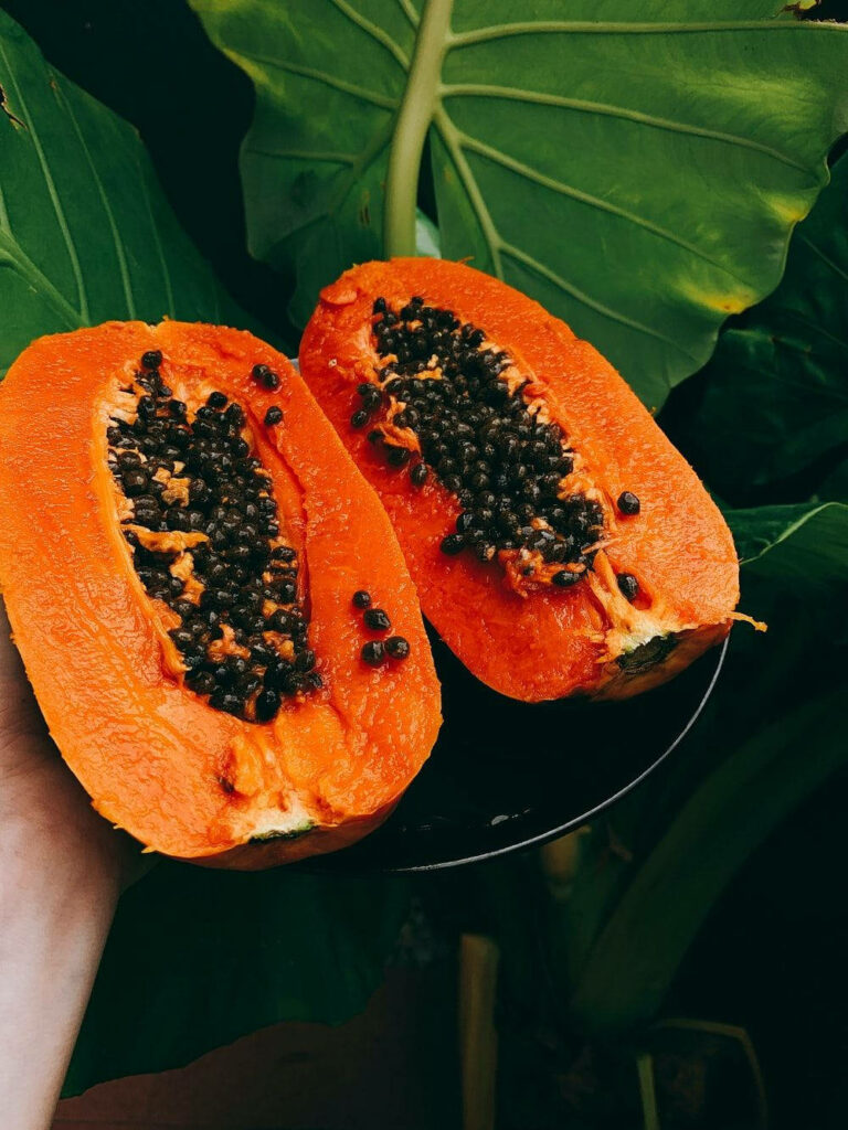 Tropical Wallpaper: Ripe Papaya Fruits on Lush Green Leaves