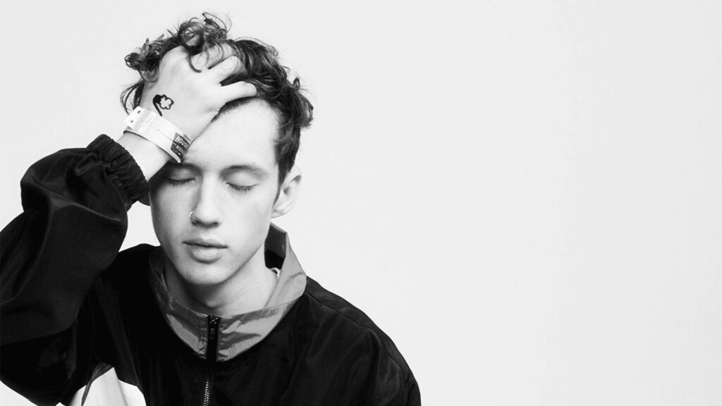 Troye Sivan black and white portrait with closed eyes hand in curly hair calm introspective background Wallpaper