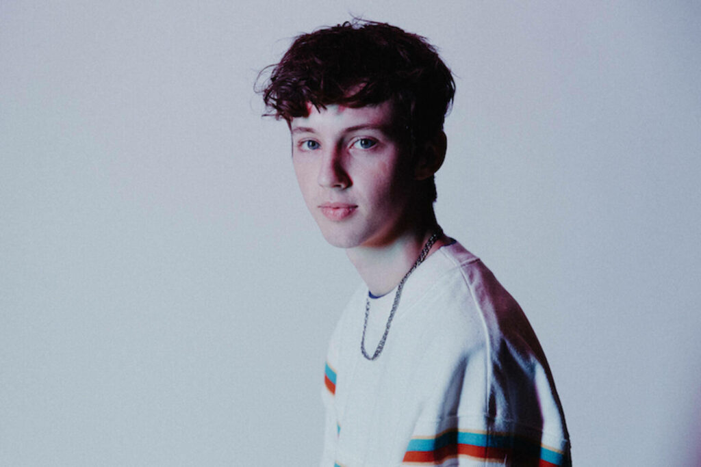 Troye Sivan pastel portrait wallpaper with soft lighting showcasing relaxed style and presence