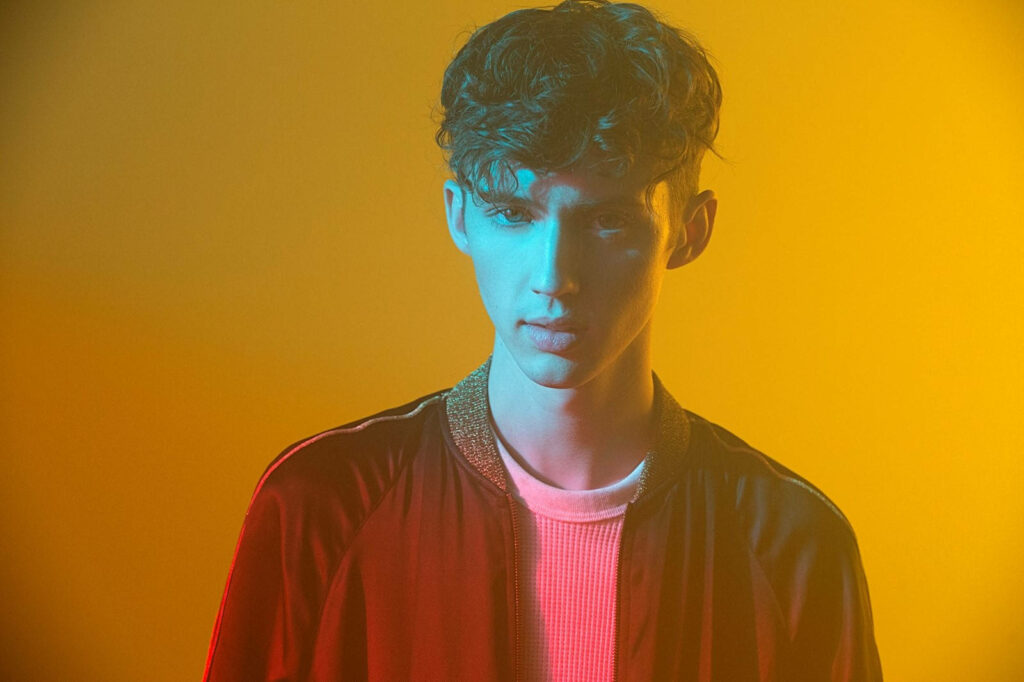 Troye Sivan vibrant wallpaper with yellow and blue lighting highlighting music icon style