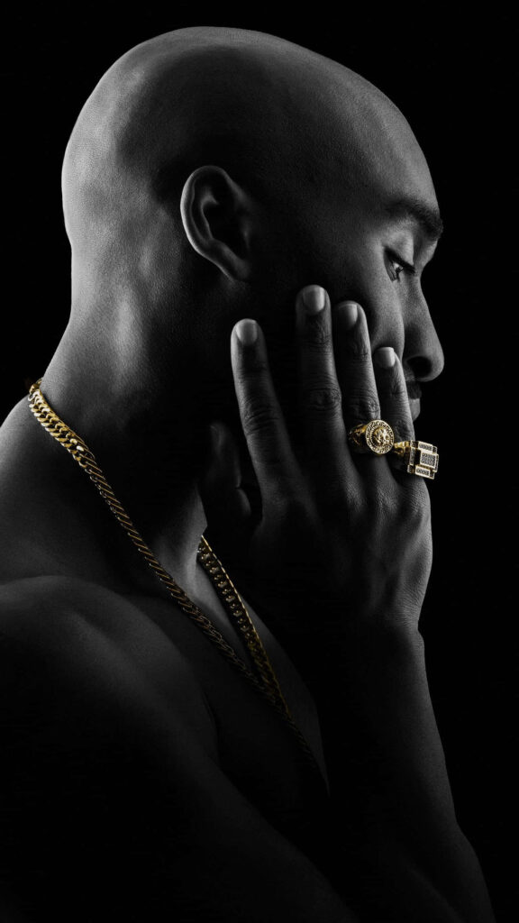 Tupac Shakur: Iconic Side Profile Portrait Adorned with Gold Accents Wallpaper