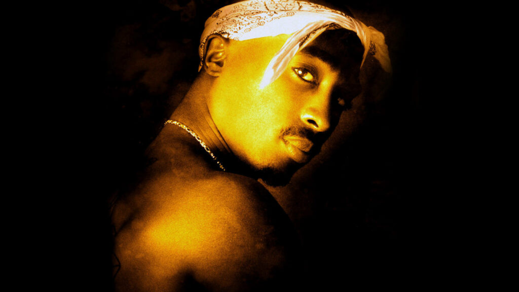 Tupac's Golden Gaze: A Captivating Yellow Photography Wallpaper.