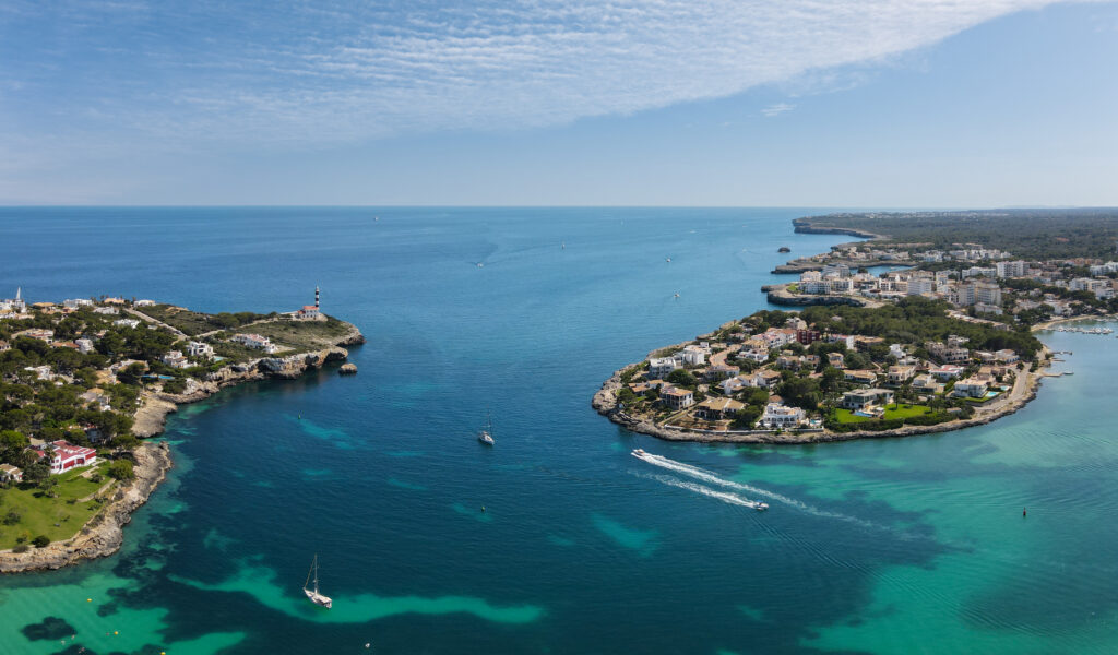 Vibrant coastal wallpaper with turquoise sea boats green islands lighthouse and bright sky