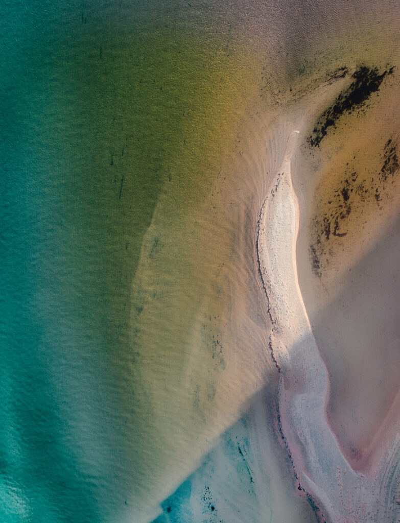 Aerial view of serene turquoise coastline with sandy shores and green gold gradients wallpaper.