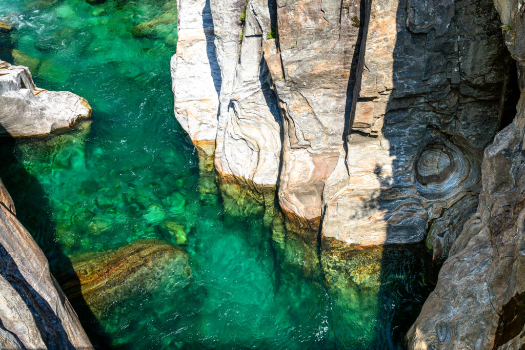 Turquoise sea with dramatic cliffside rock formations sunlit coastal landscape wallpaper background