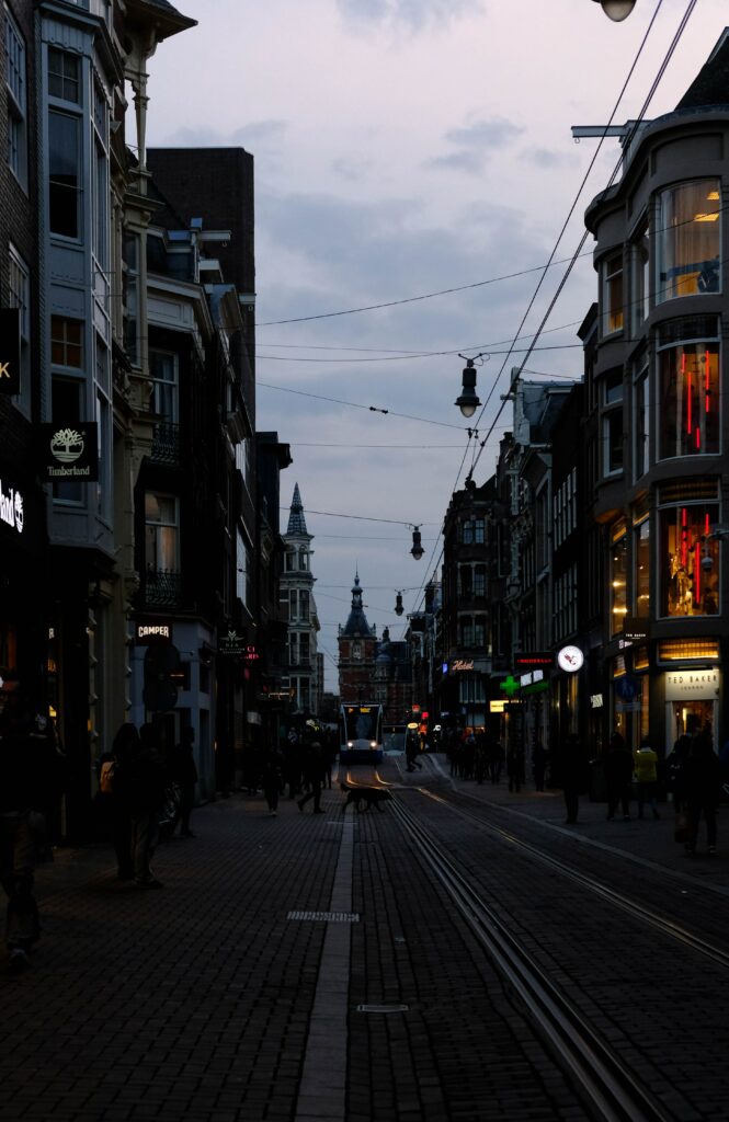 Lively Amsterdam Twilight Wallpaper: Bustling Streets & Iconic Trams