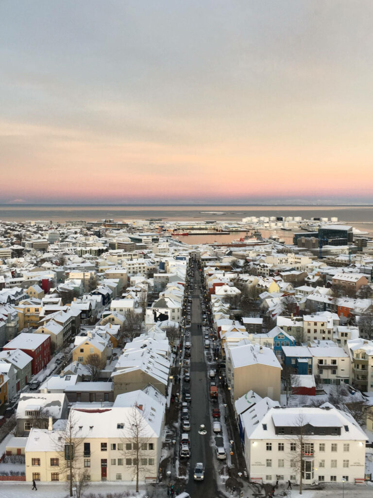 Twilight Cityscape: Colorful Snow-Lined Buildings & Serene Sea Wallpaper