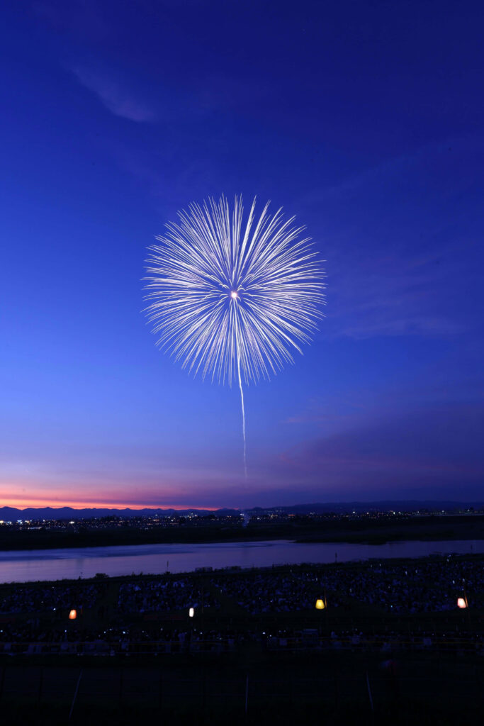 Colorful fireworks light up twilight sky above crowd celebrating festive event wallpaper background
