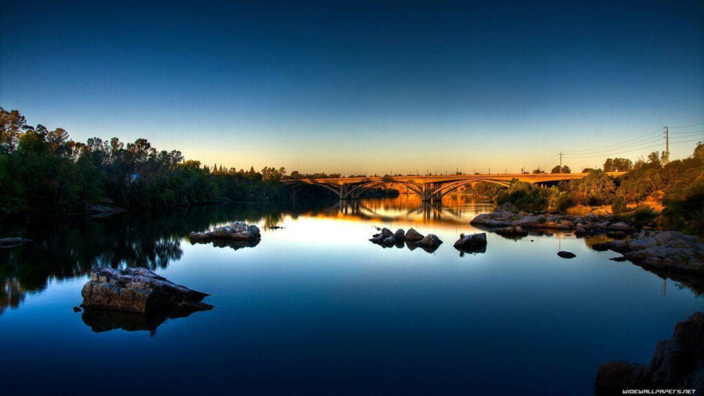 Golden Serenity: A Scenic River Bridge Wallpaper