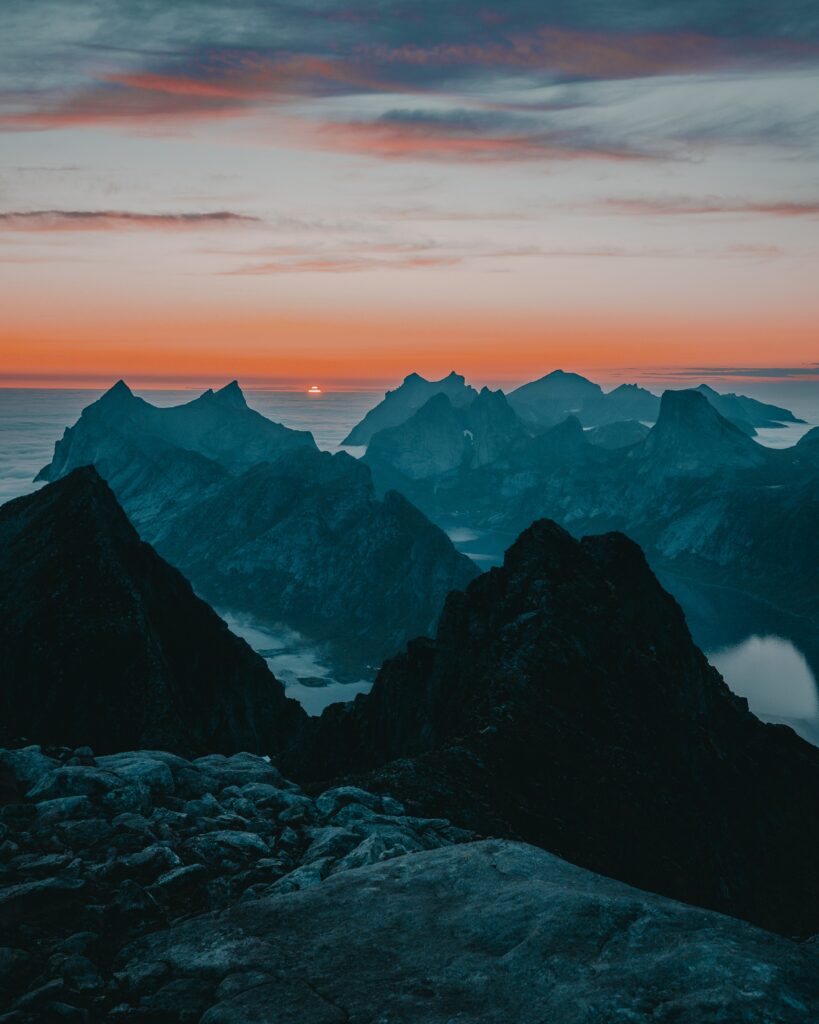 Twilight mountain landscape with rugged peaks vibrant sunset sky and dramatic rocky foreground Wallpaper