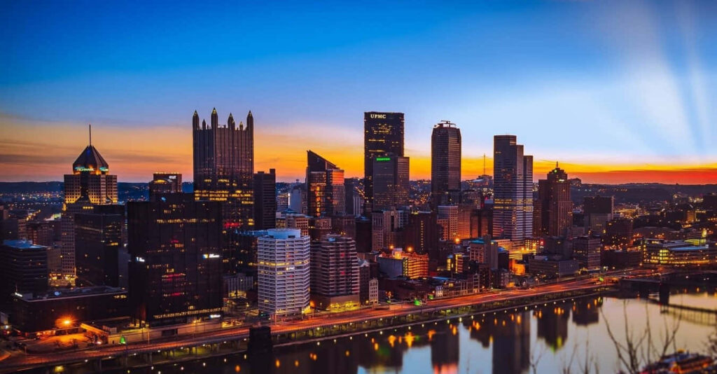 Twilight Pittsburgh Skyline Wallpaper: Warm Auburn Glow Reflection