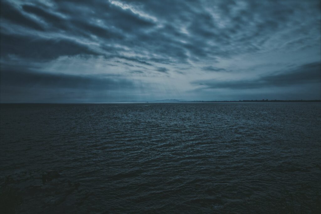 Tranquil twilight sea wallpaper with gentle ripples soft light and moody dusk tones background